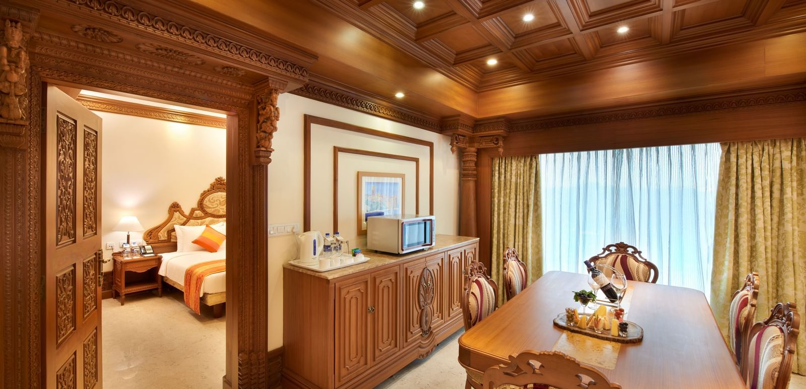 An image of a dining area with tables and chairs and a sneak peak of bedroom at Accord Puducherry